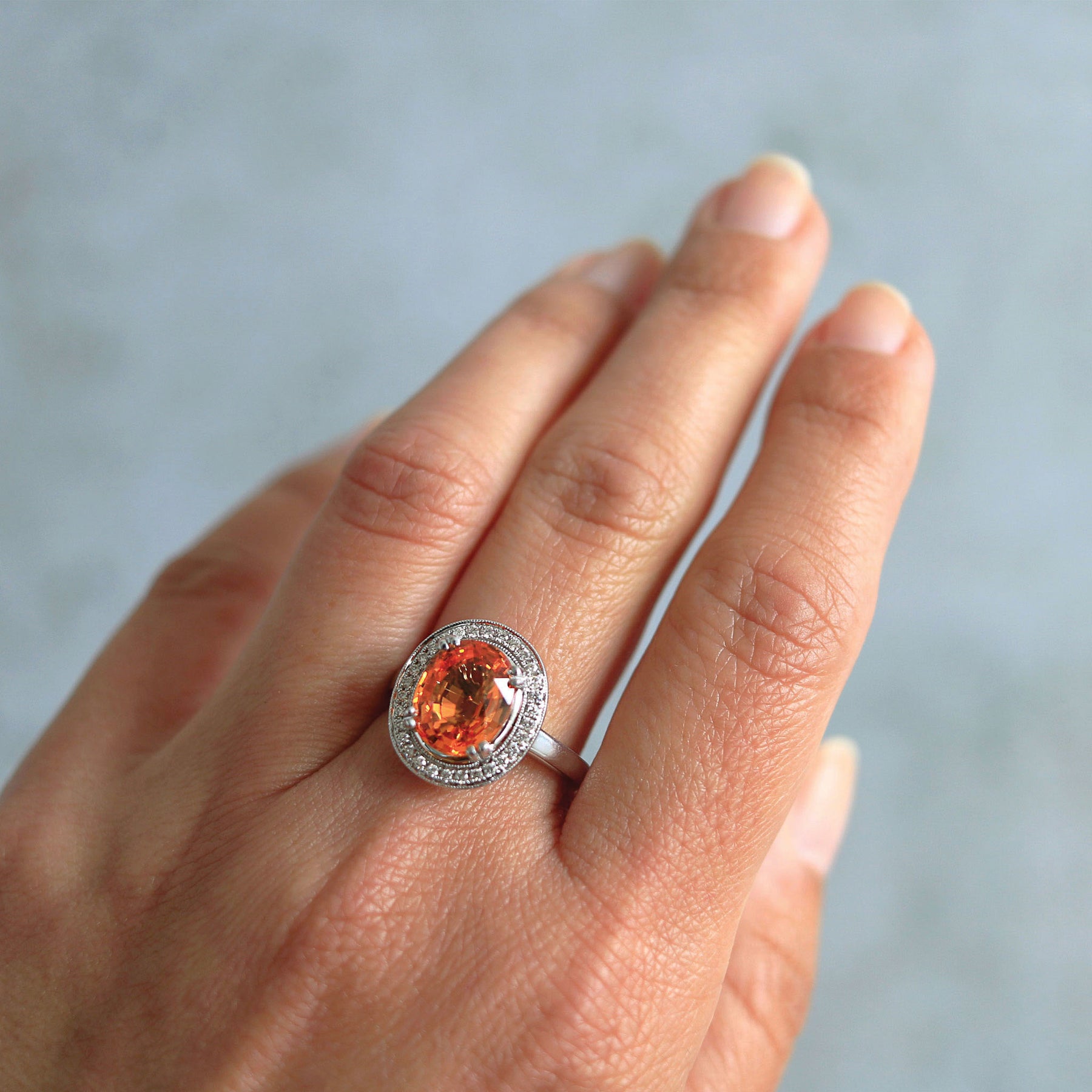 Oval Mandarin Orange Garnet and Diamond Halo Ring